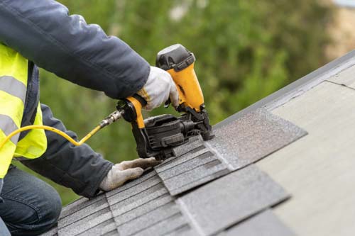 Tech installing roof shingles