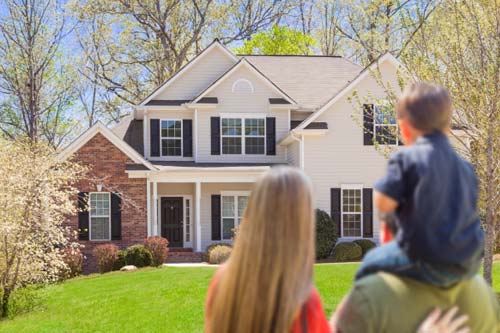 Family looking at home from front yard